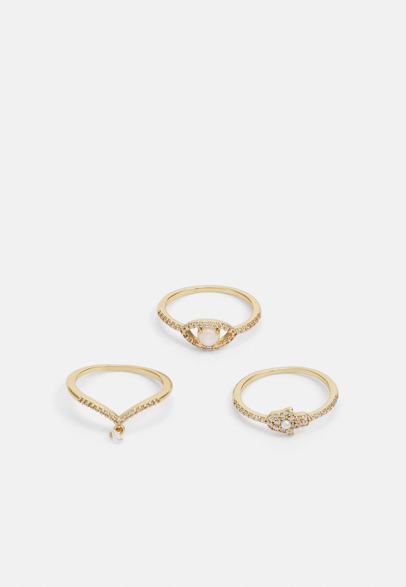Sæt med tre guld ringe. En med en struktureret bånd og en lille hængende sten, en med en oval sten omgivet af en halo af perler, og en med et udsmykket design.