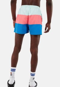 Bañador con un diseño en bloques de colores en azul claro, rosa y azul oscuro. Fabricado en material ligero y con una cinturilla elástica.