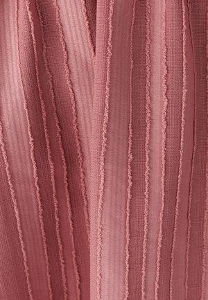 Textured fabric with vertical stripes in a muted pink hue, featuring ruffled edges and varied thickness in the pattern.