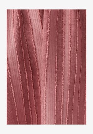 Textured fabric with vertical stripes in a muted pink hue, featuring ruffled edges and varied thickness in the pattern.