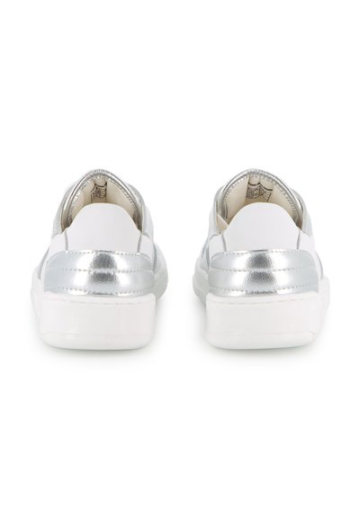 Baskets blanches avec des accents argentés au talon, vues de dos sur un fond blanc uni.