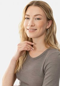 Light brown ribbed long-sleeve top with a rounded neckline. The person has long blonde hair, silver hoop earrings, and light-colored nails.