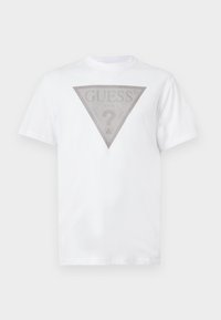 T-shirt blanc à manches courtes avec un logo triangulaire rayé gris et le mot "GUESS" au-dessus d'un grand point d'interrogation au centre de l'avant.
