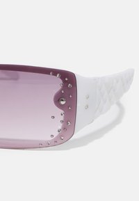 Violetti gradient-aurinkolasit valkoisella kehysrakenteella, joissa on koristeellisia kirkkaita niittejä ja teksturoitu palmikkokuvio sivuilla.