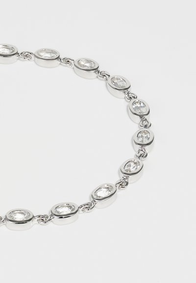 Silver chain necklace featuring oval and round clear gemstones, with smooth polished metal links connecting each stone.