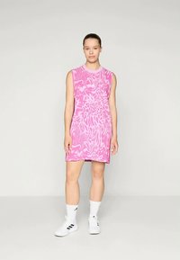 Rankovėmis nesilpninamas rožinis suknelė su abstrakčiu spiralės raštu, pagaminta iš lengvos medžiagos. Turi apvalią iškirptę ir laisvą siluetą, kuris krenta ties šlaunimi.