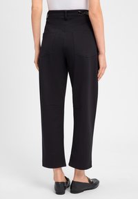 Zwarte high-waisted broek met een brede pijp, met twee achterzakken en een gladde textuur. Voorzien van een glanzende riemlus accent.