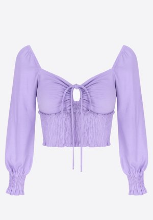 Lys lilla crop top med en smocket overdel, en nøglehul foran og lange puffærmer, der er samlet ved manchetterne. Fremstillet af strækbart stof.