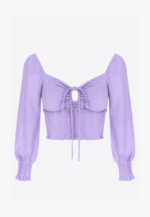Lys lilla crop top med en smocket overdel, en nøglehul foran og lange puffærmer, der er samlet ved manchetterne. Fremstillet af strækbart stof.