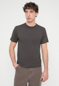 Σκούρο γκρι κοντομάνικη μπλούζα από απαλό βαμβάκι, με κλασικό στρογγυλό λαιμό και απλή, λεία υφή.