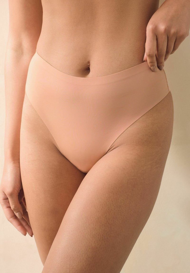 Hoge taille, naadloze nude onderbroek gemaakt van een gladde stof. Kenmerkt zich door een minimalistisch ontwerp met een comfortabele, elastische tailleband.