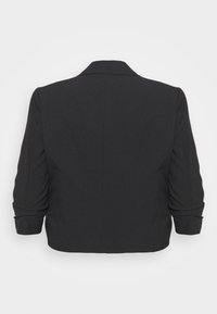 Blazer noir court avec col cranté, manches trois-quarts, et détails froncés aux ourlets des manches. Tissu lisse et texturé.