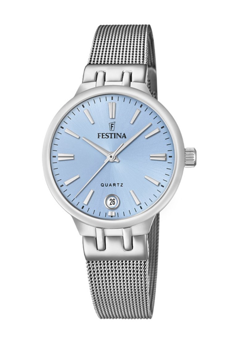 Sudraba metāla rokas pulkstenis ar apaļu zilu ciparnīcu, sudraba stundu marķieriem un metāla sietiņu. Iespējo datuma logu pulksteņa 6 stundu pozīcijā.