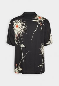 Chemise noire à manches courtes avec de grands imprimés floraux abstraits blancs et orange dans le dos et sur les manches.