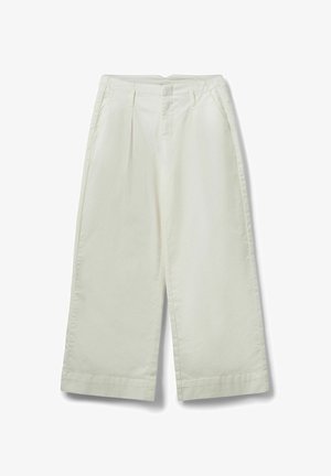 Wijde off-white broek met plooien aan de voorkant, riemlussen en zijzakken, plat gelegd op een witte achtergrond.