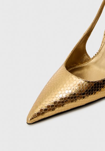 Zapato de tacón alto dorado con punta afilada y un acabado texturizado y brillante que recuerda a escamas. Los lados abiertos revelan un forro interior suave.