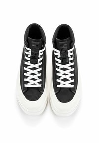 Schwarze High-Top-Sneaker aus Canvasmaterial, ausgestattet mit weißen Schnürsenkeln und einer Gummisohle. Die Zunge zeigt ein auffälliges Logo.