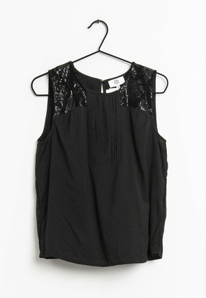 Mouwloze zwarte blouse met geplooide voorkant en schouders met pailletten, hangend aan een zwarte hanger tegen een witte achtergrond.
