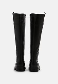 Černé kožené vysoké boty po kolena s hladkým povrchem, zaoblenou špičkou a bočním zipem pro snadné obouvání. Detailní prošívání na zadní straně.