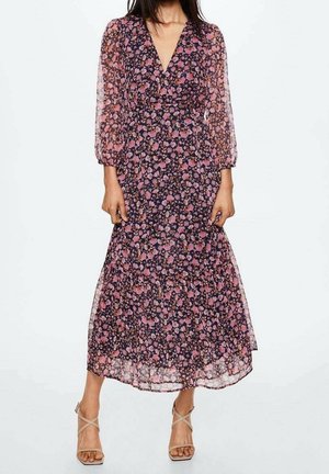 Robe longue fleurie avec un décolleté en V, des manches longues transparentes, une base sombre, des fleurs roses et violettes, et une jupe fluide à volants.