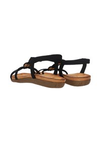 Sandales noires à brides avec une tige en tissu noir texturé, semelle intérieure rembourrée et semelle en caoutchouc marron. Design léger avec un profil plat.