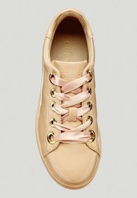 Vaaleanpunaiset synteettiset lenkkarit, joissa on satiininarut, kultaiset silmukat ja kohokuvioitu logo sisäpohjassa. Pyöristetty kärki ja minimalistiinen muotoilu.