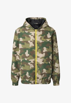 Álcázott kapucnis dzseki sárga elülső cipzárral, rugalmas mandzsettákkal és szegéllyel, oldalzsebekkel, valamint "bruno banani" logóval a mellrészen.