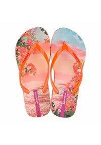 Infradito con cinturini arancioni e un design floreale multicolore con fiori rosa su uno sfondo di spiaggia al tramonto.
