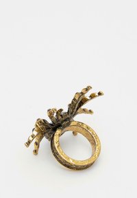 Anello in tono oro con intricato design floreale sulla parte superiore, caratterizzato da una superficie testurizzata e una fascia aperta per una vestibilità regolabile.