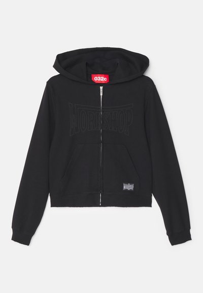 Black zip-up hoodie made of soft fabric, featuring a large "WORKSHOP" print on the front, kangaroo pocket, and a cropped design.