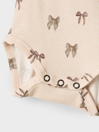 Ribbat, ljusrosa bodysuit med små, mönstrade rosetter i dämpade färger. Tryckknappar vid grenen för enkel påklädning.