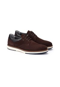 Chaussures en daim marron avec des accents en cuir noir, à bouts ronds et semelles beiges. Présentent des œillets simples et une texture lisse.