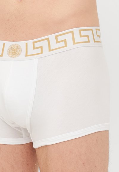 Boxeri albi din bumbac moale, având un elastic cu accente aurii, decorat cu un model în formă de cheie grecească și detaliu cu logo-ul Medusa.