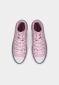 Ζευγάρι ροζ καμβαδένια ψηλά αθλητικά παπούτσια με λευκά κορδόνια, λευκά λαστιχένια καλύμματα στα δάχτυλα και μικρά μοβ αστέρια, σε θέα από πάνω.