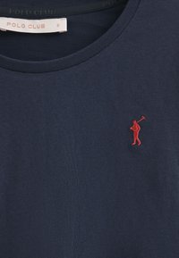Navyblaue Baumwoll-T-Shirt mit einem runden Ausschnitt und einer kleinen roten gestickten Figur mit einem Golfschläger auf der linken Brust.