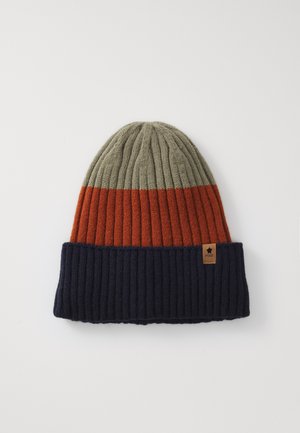 Bonnet en tricot côtelé avec trois blocs de couleurs : partie supérieure en olive, partie centrale en orange rouille, et revers bleu marine avec une petite étiquette marron.