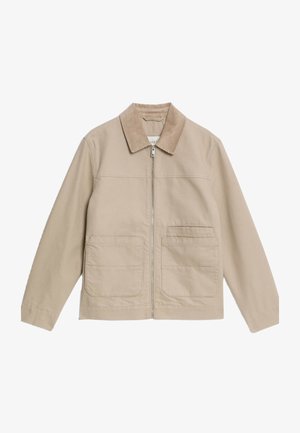 Beżowa kurtka zapinana na zamek z kołnierzem z materiału sztruksowego, dwiema dużymi kieszeniami naszytymi z przodu oraz mniejszą kieszenią na piersi po prawej stronie.