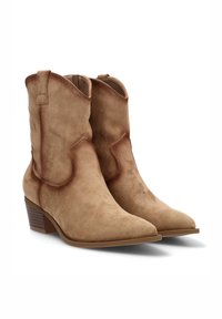 Botas de cowboy de ante marrón con punta afilada, detalles de costura y un tacón bajo en bloque. Presentan una pestaña de tirón para facilitar su uso. Textura suave.