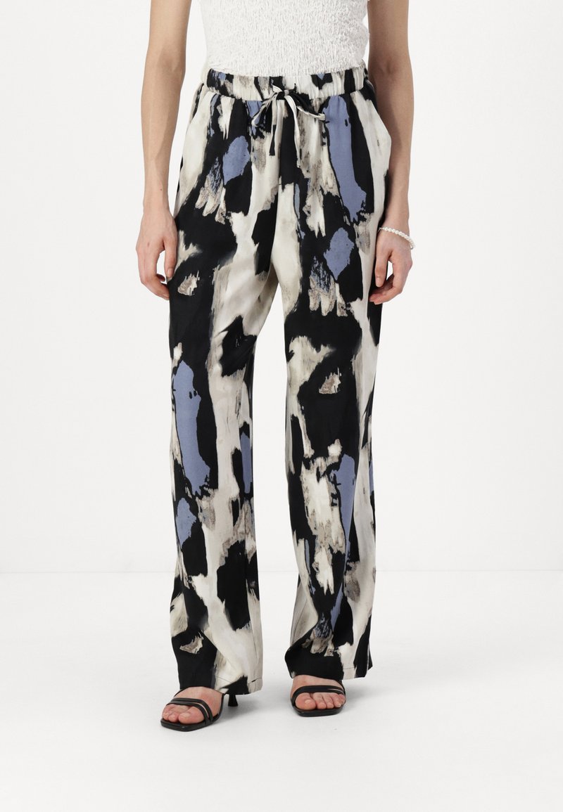 Wide-leg pants in a silky fabric featuring a black, white, and blue abstract pattern. Elastic waistband with adjustable drawstring.