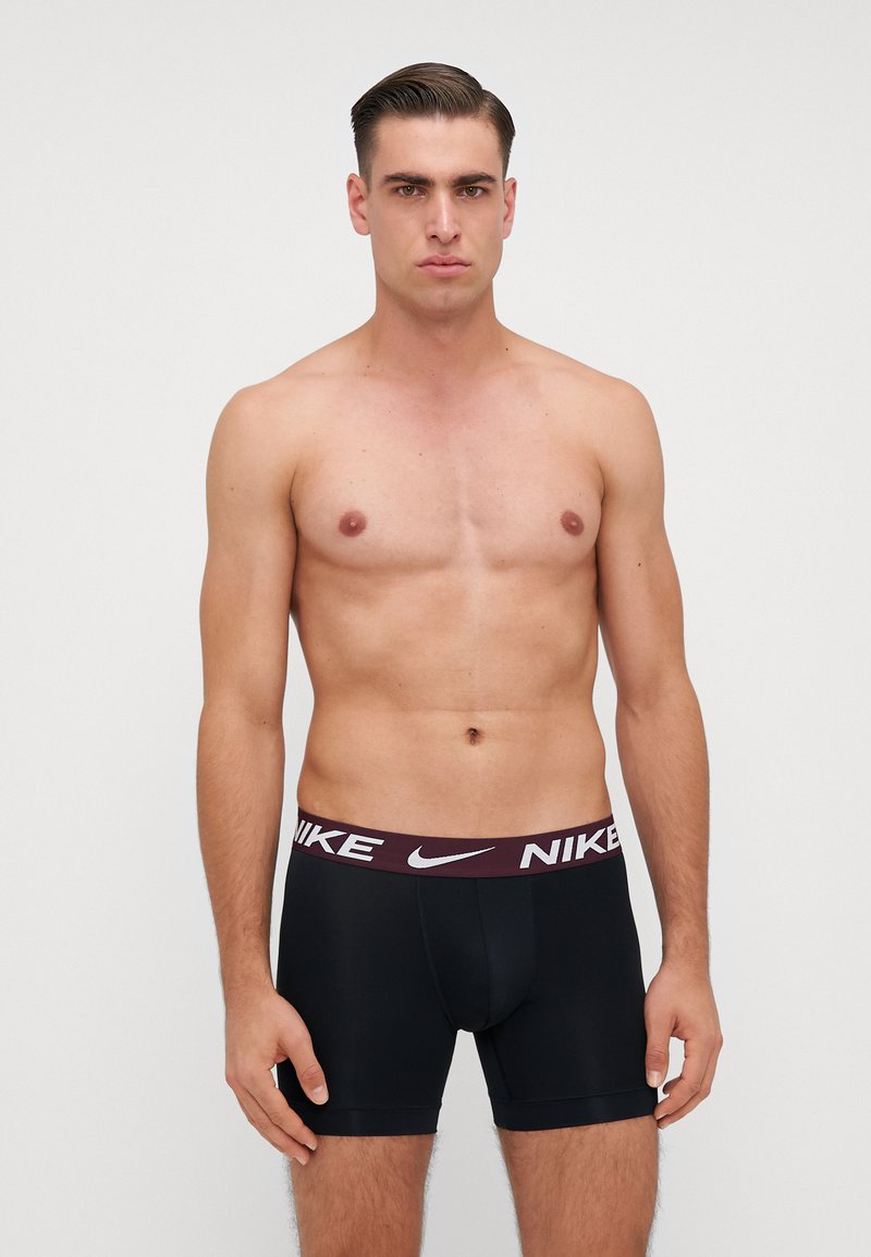 Čierne boxerky s bordo pásom s logom Nike v bielej farbe. Hladká textúra a priliehavý dizajn. Žiadne viditeľné vzory.