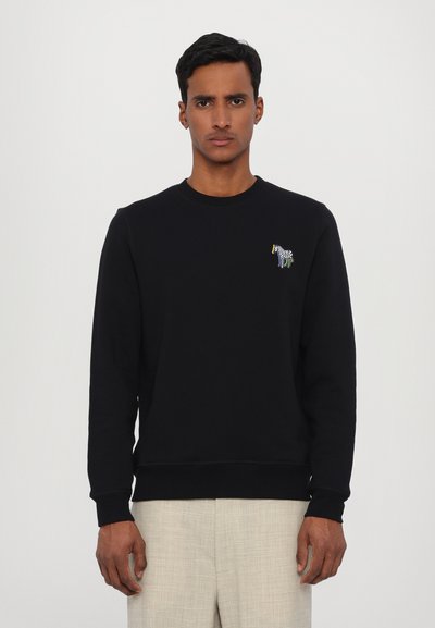 Sweatshirt en coton noir avec col ras du cou, présentant un motif de zèbre brodé sur la poitrine gauche. Texture lisse, coupe régulière, poignets côtelés.