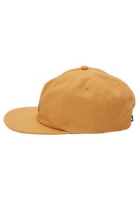 Gul hat med en flad skygge, seks paneler og et broderet logo på forsiden. Lavet af stof med en glat tekstur.