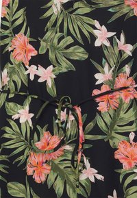 Květinové šaty s černým pozadím, na kterém se vyjímají živé růžové a bílé květy, zelené listy a detaily v oblasti pasu na zavázání.