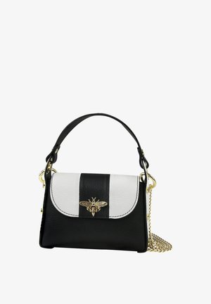 Black and white leather handbag with a gold bee emblem on the flap, black handle, and gold chain strap coiled at the side.