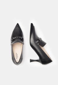 Zwarte leren hoge hakken met een spitse neus, met een gebogen hak en een decoratieve band met riemdetail aan de voorkant.