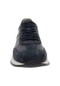 Zapatillas de ante y tela en azul oscuro con cordones en la parte delantera y suela blanca, vistas de frente sobre un fondo blanco.