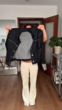 Fekete farmerdzseki szürke béléssel, kontrasztos fehér varrással és gombokkal. Az ujjak felgöngyölhetők, hogy a szürke anyag láthatóvá váljon alatta.