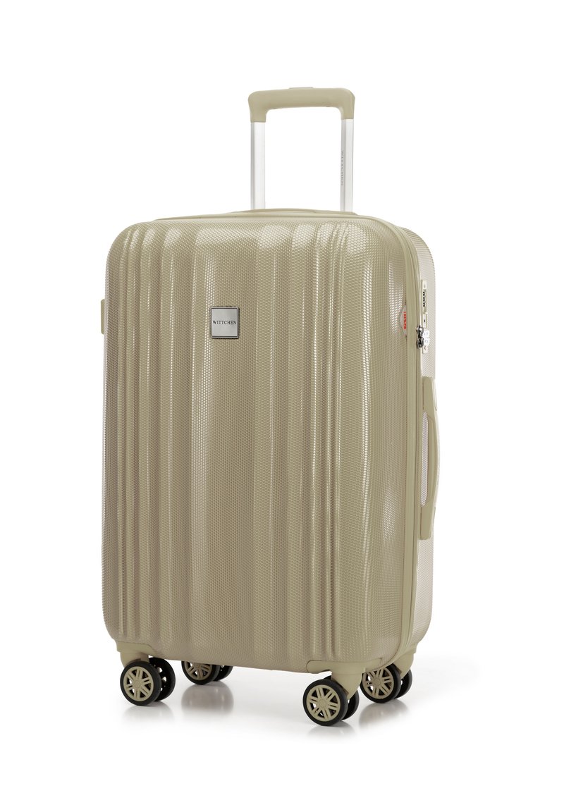 Maleta rígida en beige con superficie texturizada, que cuenta con un mango telescópico y cuatro ruedas giratorias para una fácil maniobrabilidad.