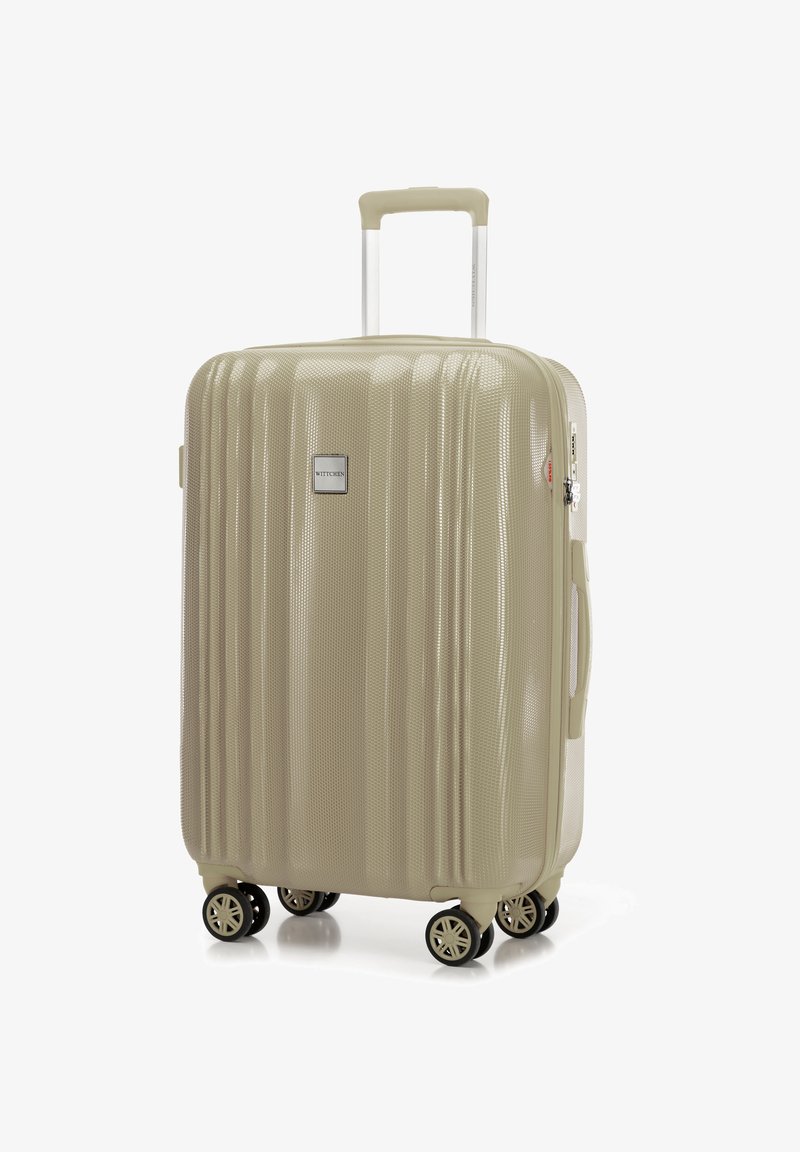 Valigia rigida beige con superficie texturizzata, dotata di manico telescopico e quattro ruote girevoli per una maggiore manovrabilità.