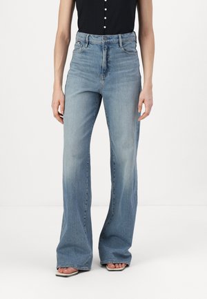 Light blue high-waisted flared jeans with a faded finish, five-pocket design, and a button closure. Features subtle stitching details.